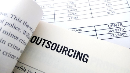 Obraz premium Outsourcing word on book