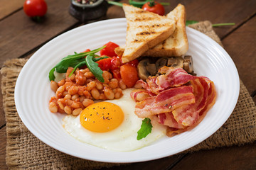 English breakfast - fried egg, beans, tomatoes, mushrooms, bacon and toast