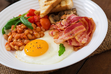 English breakfast - fried egg, beans, tomatoes, mushrooms, bacon and toast