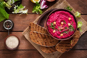 Fotobehang Roasted Beet Hummus with toast in a ceramic bowl on a wooden background. Top view © timolina