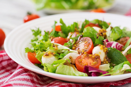 Dietary salad with tomatoes, mozzarella lettuce with honey-mustard dressing