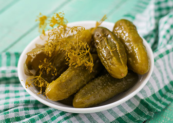 Pickled cucumbers on a light wooden background