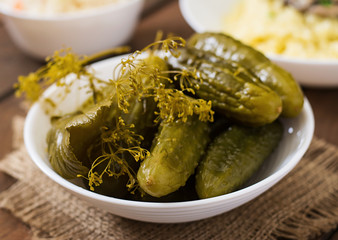 Pickled cucumbers on a dark wooden background.