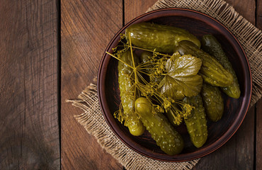 Pickled cucumbers on a dark wooden background. Top view