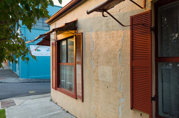 Old House on the Street with Wooden Shutters at Sunset