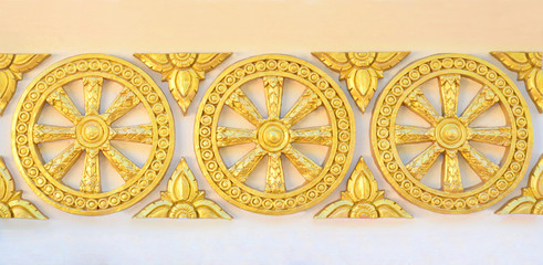 Thai style golden molding wheel of life pattern on temple wall