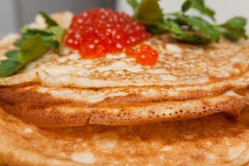 Pancake with red caviar on table