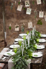 Weddind table setting with white plates and green glasses decora