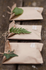 Three brown craft gift boxes decorated with fern and ivy leaves