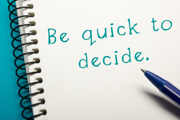 Be quick to decide - Office table top view. Notepad with text and pen 