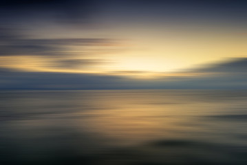 Beautiful vibrant sunrise landscape over calm sea wtih blur filt