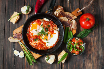 fried eggs with bacon in a pan close-up 