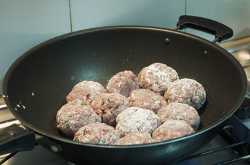 Cooking the meat balls using a pan.