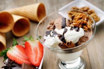 Ice cream sundae, waffle cone and sliced strawberry