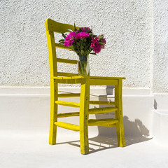 Fresh pink spring flower bouquet on old yellow chair