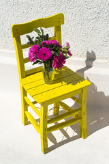 Fresh pink spring flower bouquet on old yellow chair