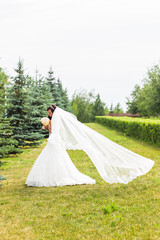 Fototapeta premium Beautiful bride with bouquet of flowers outdoor