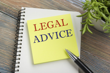 Legal Advice. Notepad with message, pen and flower. Office supplies on desk table top view