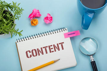 Content, online concept. Notepad with message, pen, coffee cup and flower. Office supplies on desk...
