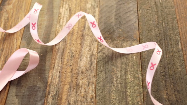 Womens health symbol in pink ribbon on wooden board