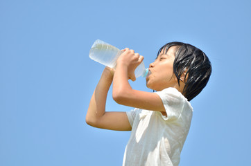 青空で水を飲む女の子