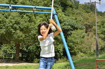 Fototapeta premium 公園の遊具で楽しく遊ぶ女の子