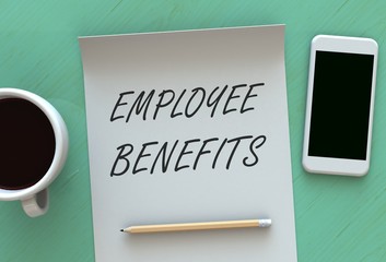 EMPLOYEE BENEFITS, message on paper, smart phone and coffee on table