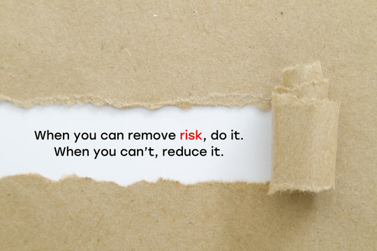 "When you can remove risk, do it. When you can't, reduce it. " slogan written under torn paper. Risk management concept.
