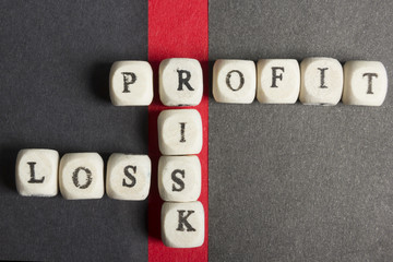 Profit, loss and risk crossword blocks on table. Top view