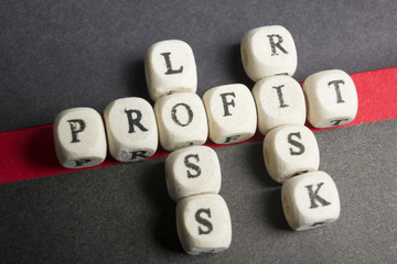 Profit, loss and risk crossword blocks on table. Top view