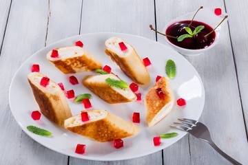 sweet rolls of pancakes or crepes with goat cottage, close-up