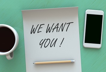 WE WANT YOU, message on paper, smart phone and coffee on table