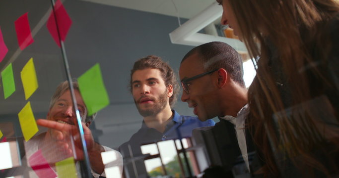 African-american man explaining brainstorming to business team in startup office