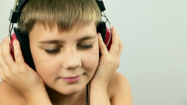 Teen Boy child music lover fan listens music in headphones, audio player