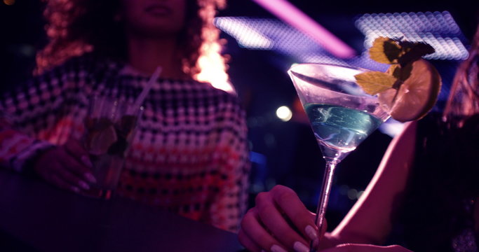 Party girls happy toasting martinis at nightclub