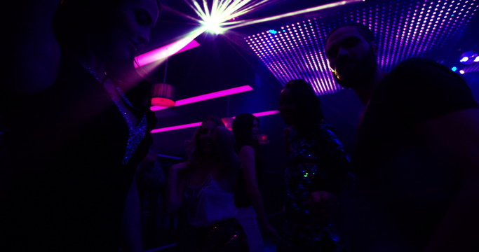 Woman and party friends enjoying music and dancing in nightclub