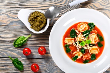 tortellini soup with italian sausages, spinach, tomato, parmesan cheese , pesto-sauce