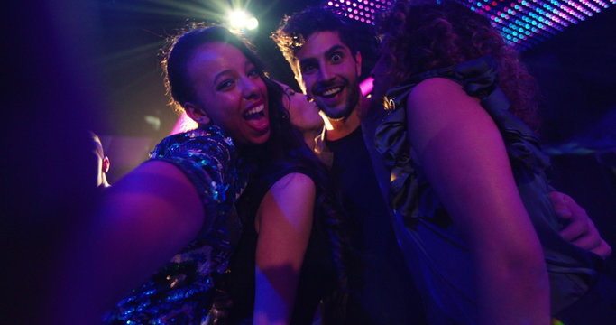 Multi-ethnic party friends making silly faces and posing