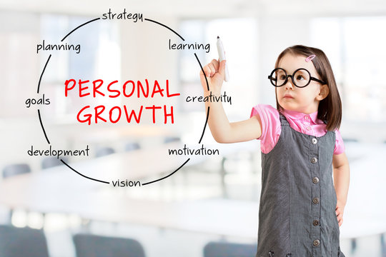 Cute little girl wearing business dress and drawing circular structure diagram of personal growth concept. Office background.