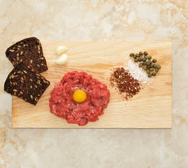minced beef with raw egg on a wooden Board