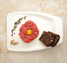minced beef with raw egg on a white Board tray