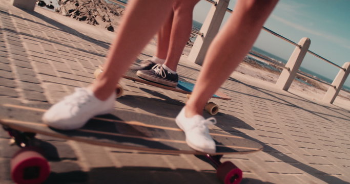 Unrecognizable low angle shot of teenage girls riding skateboards