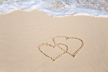 Two hearts drawn on the beach sand