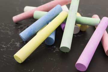 multicolored crayons on a black background
