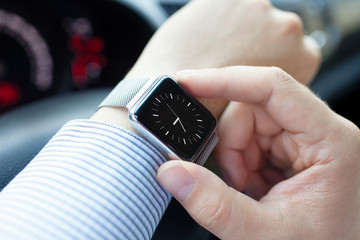 man driving a car with smart watch on the hand