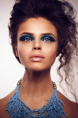 Beauty studio portrait of  sun-tanned woman with bright blue and