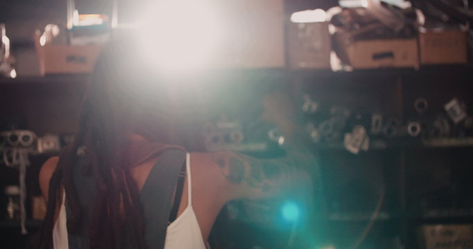 African-american fetching metal pipes shelved in a workshop