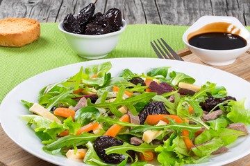 mixed lettuce, spinach, carrot, ham, cheese and prunes salad , top-view
