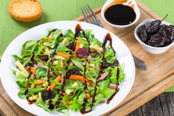 mixed lettuce, spinach, carrot, ham, cheese and prunes salad , top-view