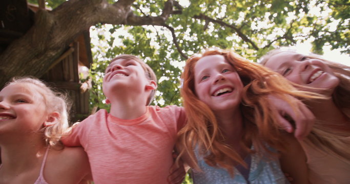 Children playing on a rustic wooden fence in a park